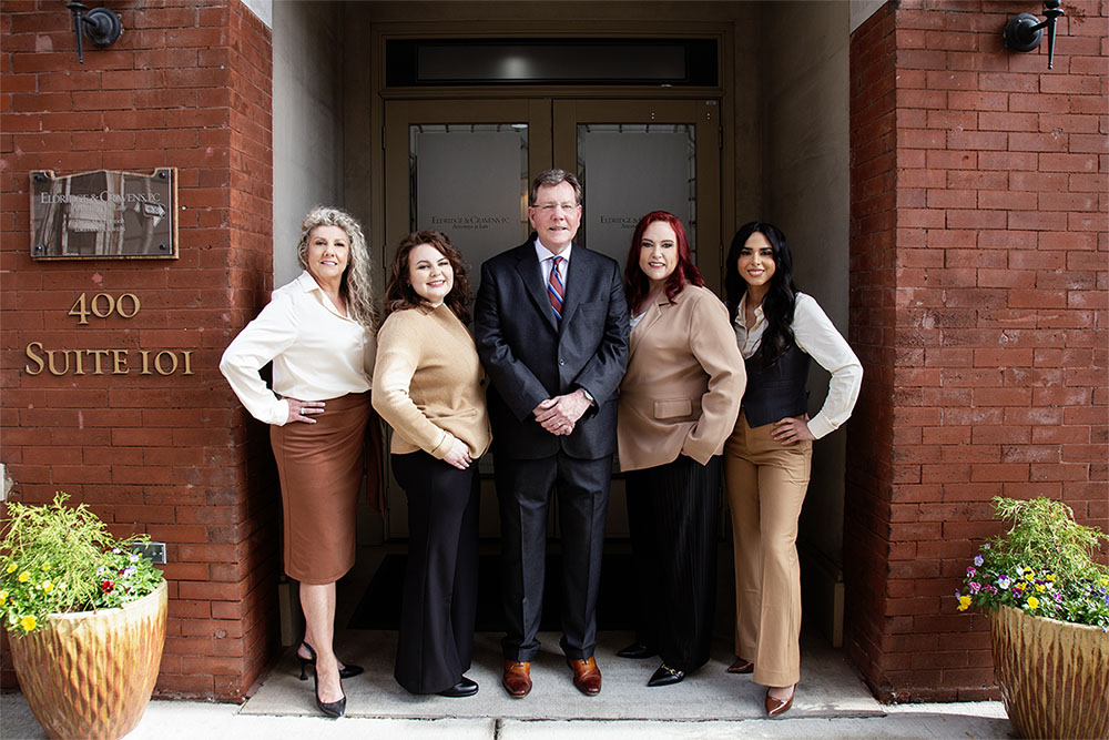 The attorneys and staff of Eldridge & Cravens standing in front of their office at 400 Suite 101, smiling and ready to serve clients.