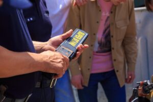 Police officer with metal detector and student nearby representing public intoxication enforcement and University of Tennessee student defense in Knoxville