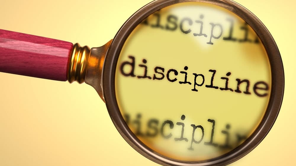 Magnifying glass over the word discipline symbolizing accountability