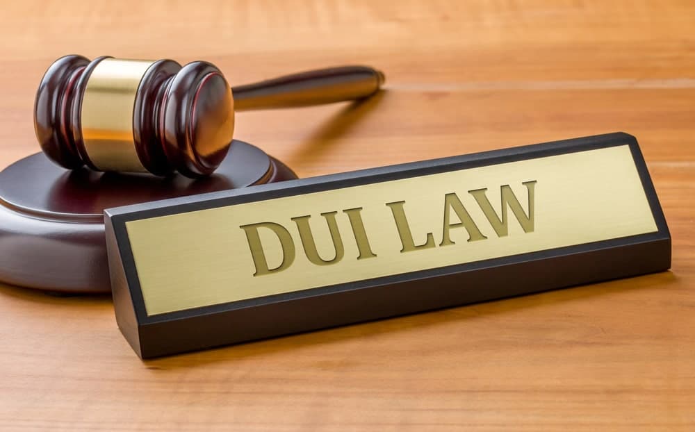 Image is of a courtroom gavel next to a plaque labeled DUI Law, symbolizing the legal consequences students may face after a DUI charge.